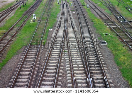 Railway, the top view on rails. Leading parallel steel rails with regular crossbars. Abstract geometric view.