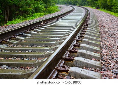 Railway Track  In A Green Forest. Cloudy Weather And Rain. Railroad Track Vanishing Into The Distance.