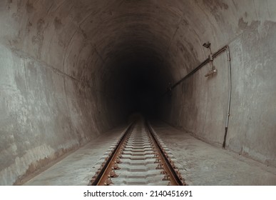 Railway Track Leading Lines Into The Dark Train Tunnel Entrance. Traveling By Train, Space For Text, Selective Focus.