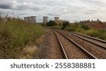 a railway track leads the viewer to five cooling towers at a power station in the distance. Located in Willington, Derbyshire