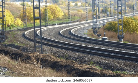 railway track railway track metal steel highway transportation cargo passenger traffic locomotive contact network winding turn trees yellow foliage autumn Close-up natural rear view traffic light plat - Powered by Shutterstock