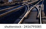 Railway track panorama with high contrast at evening twilight. Reflecting and glistening rails, switches and crossings on main line in Hagen Germany. Technical infrastructure and symbolic background. 