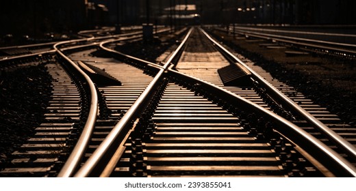 Railway track panorama and switches at station in Sauerland Germany with geometrical structure and vanishing point. Warm evening sunlight reflected by bright steel surface, screws and thresholds. - Powered by Shutterstock