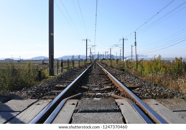 The\
railway tracks running on the rural area in\
Japan.
