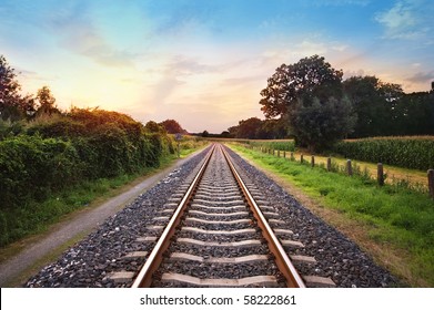 railway tracks in a rural scene with nice pastel sunset - Powered by Shutterstock