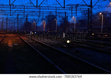 Railway tracks, semaphores, lights in the evening and light fog
