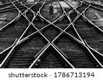 Railway tracks with switches and interchanges at a main line station in Frankfurt Main Germany with geometrical structures, thresholds, gravel and screws. Reflecting symmetrical rails black and white.