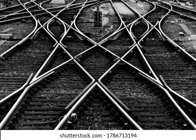 Railway tracks with switches and interchanges at a main line station in Frankfurt Main Germany with geometrical structures, thresholds, gravel and screws. Reflecting symmetrical rails black and white