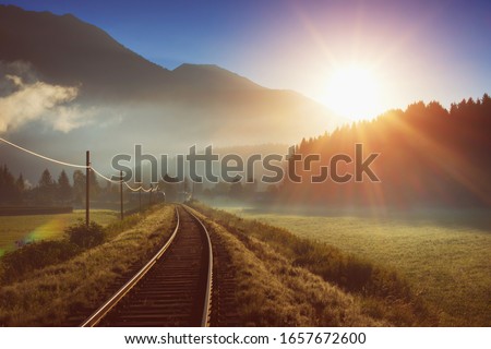 Railway and train in the Alpes at sunrise