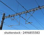 Railway train cables and electricity on a beautiful blue sky background. Electric lines over the train tracks