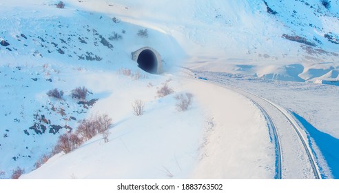 Railway tunnel  with railroad in snowy mountains -The Railway tracks under the snow tunnel - Powered by Shutterstock