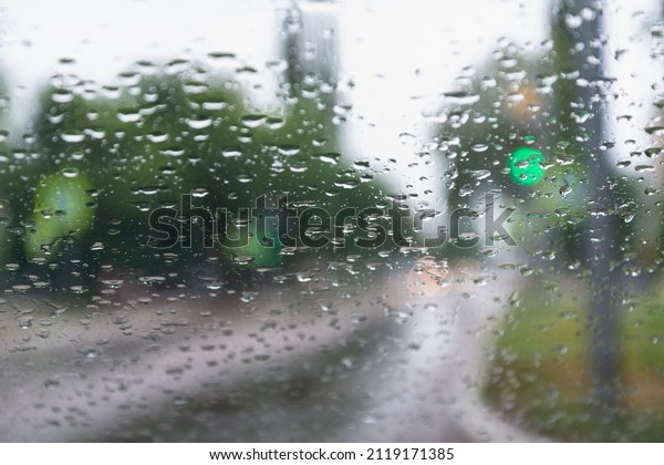 Rain behind\
the glass of the car. Concept: bad weather, poor visibility,\
downpours, danger driving a car, after\
rain.