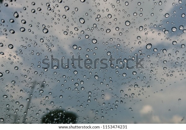rain behind a window. rain drops on glass. cars on the\
road. 