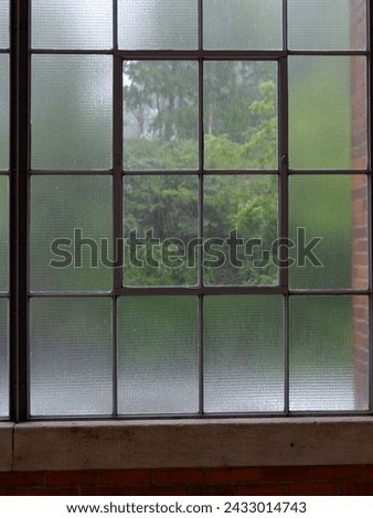 Rain behind window which is composed from two different types of class - clear and matte. 