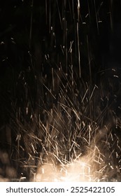Rain bouncing off a spot light creating an electric effect of sparks flying through the air