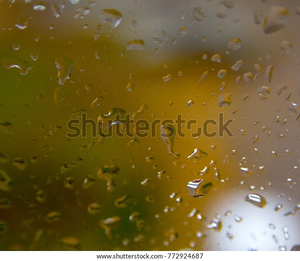 Rain in\
the city of a drop of water on a wet\
glass.