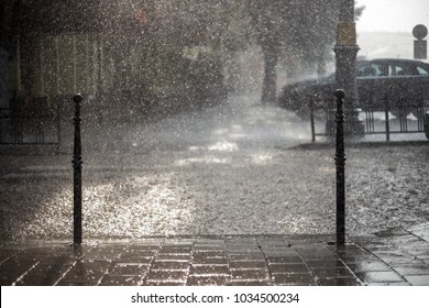 Rain in the city. Road, pavement, car in rain, close up. Water splashes, spills on roadway. - Shutterstock ID 1034500234