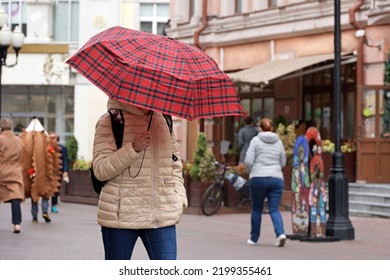 Rain In A City, Woman With Umbrella Wearing Jacket Walk On A Street On People Background. Rainy Weather In Autumn