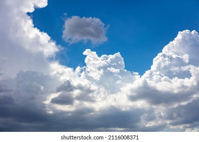 Rain cloud on blue sky background. Fluffy cumulus cloudscape white and grey shade color. Weather, meteorology concept