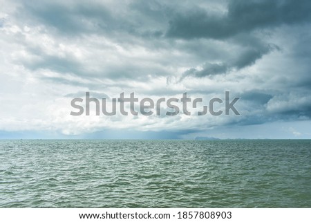 Rain cloud over turbulent sea in the rainy season of tropical island. Samui island, Thailand. Seascape before raining. Dark storm clouds made overcast ambiance. Natural disaster. Nimbostratus clouds. 