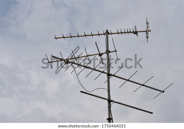 Rain clouds blow quickly in sky,\
Rain clouds and old TV antennas. Old old television\
antenna.