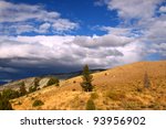 Rain clouds form in the evening over a sunlit landscape of Yellowstone National Park