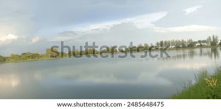 Rain clouds preparing to fall, light reflected in the pond and trees receiving light.  and roads where people come to relax in parks