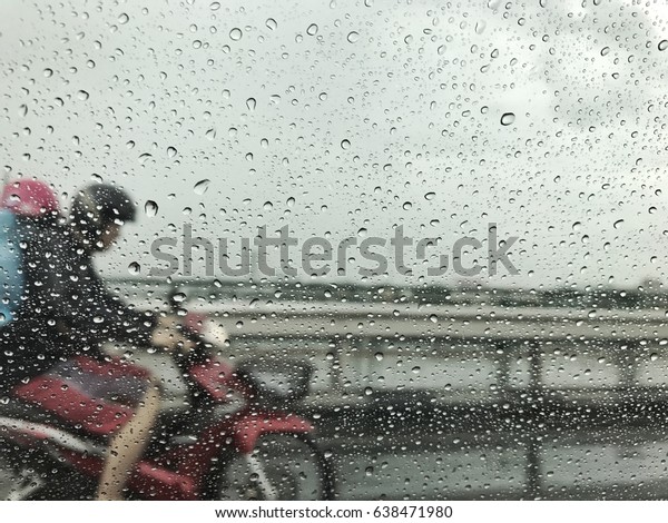 Rain\
coated on the car mirror drive along with\
motorcycle