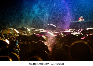 Rain colored by music. Heavy shower hits the crowd during Dj's set.
