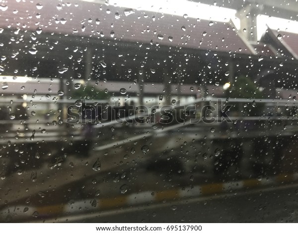 Rain drop\
with background of blurred train\
station