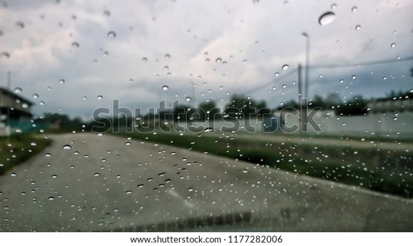 Rain drop on the car glass. Road\
view through car window with rain drops, Driving in\
rain.