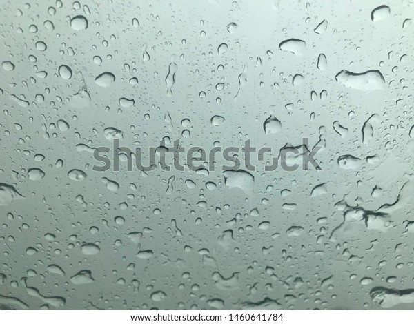 Rain drop\
on car glass ,raining season,\
background.