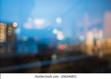 rain drop on clear glass window, reflection of blurred airport terminal and light bokeh from outside, beautiful color abstract for background