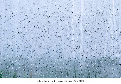 Rain drop on glass window at day time in monsoon season with blurred background. - Shutterstock ID 2164722783