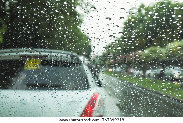 rain drop on window or car Windshield with\
disturb or making driving problem. Photo of car shoot from inside\
of another car wiht\
unclear.