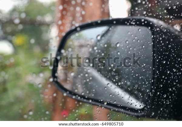 Rain\
drop on the window and a glass outside the car in the raining day.\
Selective focus. Transportation and nature\
concept.