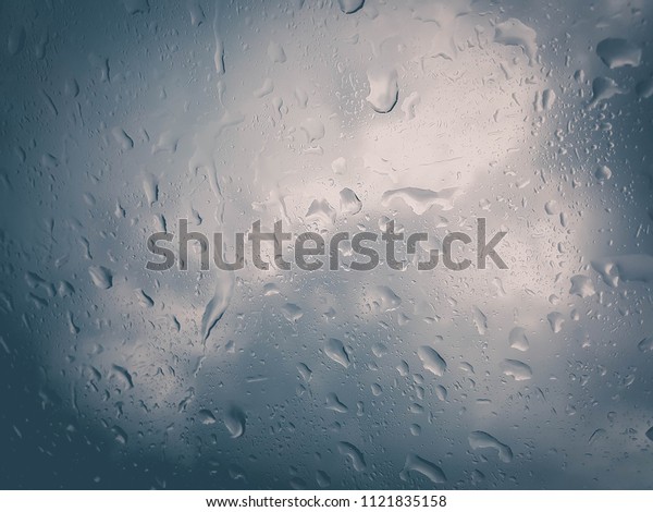 rain
droplet on car window on white and blue
background