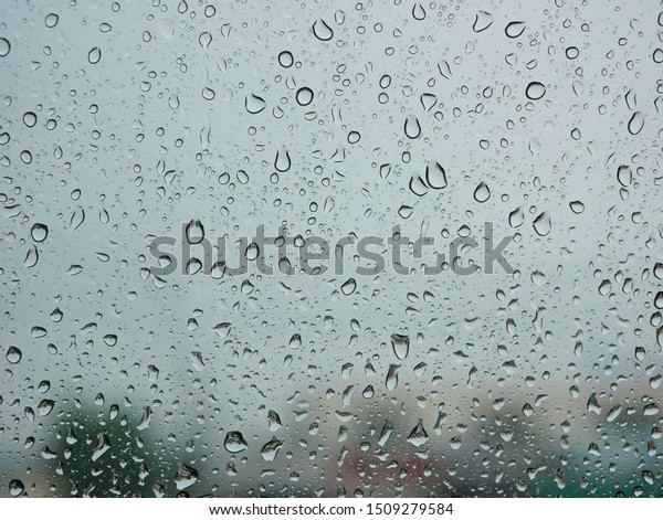 Rain droplets on a car\'s window on a rainy\
day - driver\'s perspective