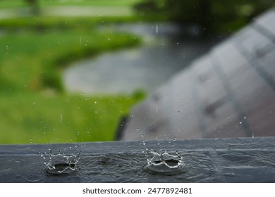 Rain droplets splashing on flat window ledge - Powered by Shutterstock