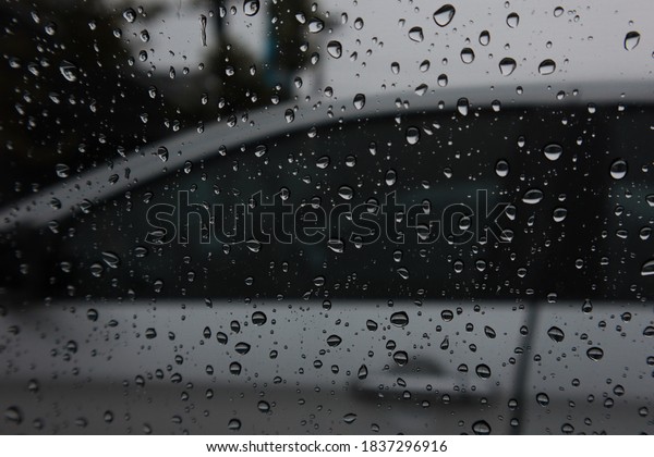 Rain\
drops adhere to the glass of the car on a rainy\
day