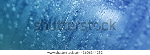 Rain drops blue on window glasses  with\
cloudy background.rain bubbles car . Natural Pattern of raindrops\
on cloudy background.\

