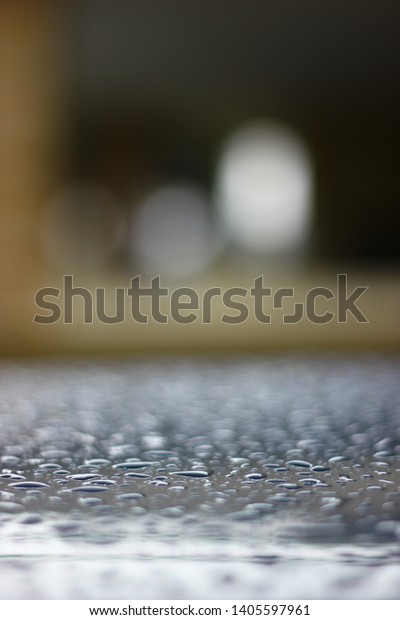 rain drops and\
car roof top with reflection\
