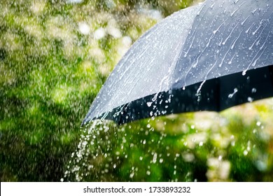 Regenfälle fallen aus einem schwarzen Schirmkonzept für schlechtes Wetter, Winter oder Schutz