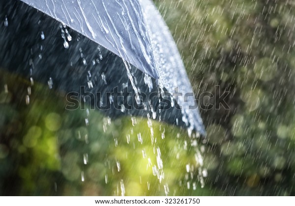 Rain drops falling from a black umbrella concept for bad weather, winter or protection