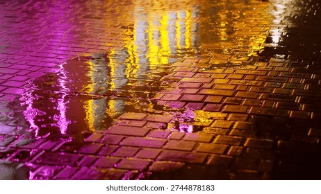 Rain drops falling into puddle on cobblestone street at night, illuminated by pink and orange city lights. Reflections and ripples create a cinematic urban atmosphere with moody, futuristic vibes.