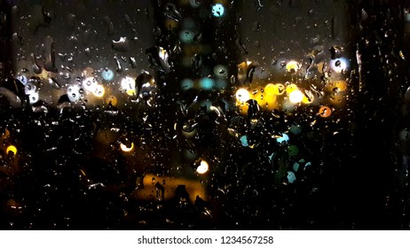 Rain drops and light reflection on the window at night