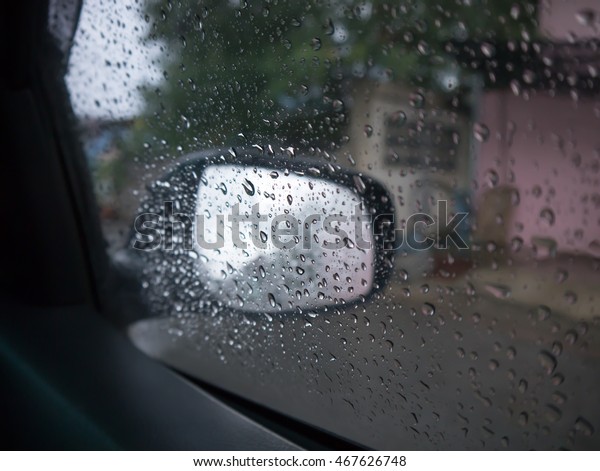 Rain\
drops on auto glass view in car see side\
mirror
