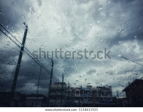 Rain drops on\
car with dark clound\
background