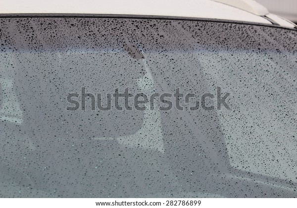 rain drops on car glass in rainy
days ,water drop on glass mirror abstract
background.