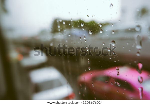 Rain drops on car window with road light bokeh.
Stock image of rain drops on car glass in rainy season abstract
background, water drop on the glass, night storm raining car
driving concept